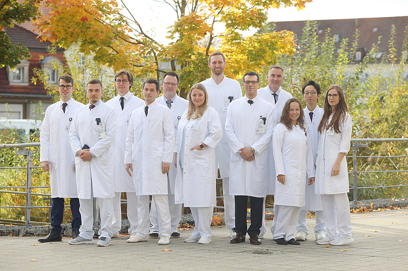 Team der Neurochirurgie in weißen Kitteln in der Natur